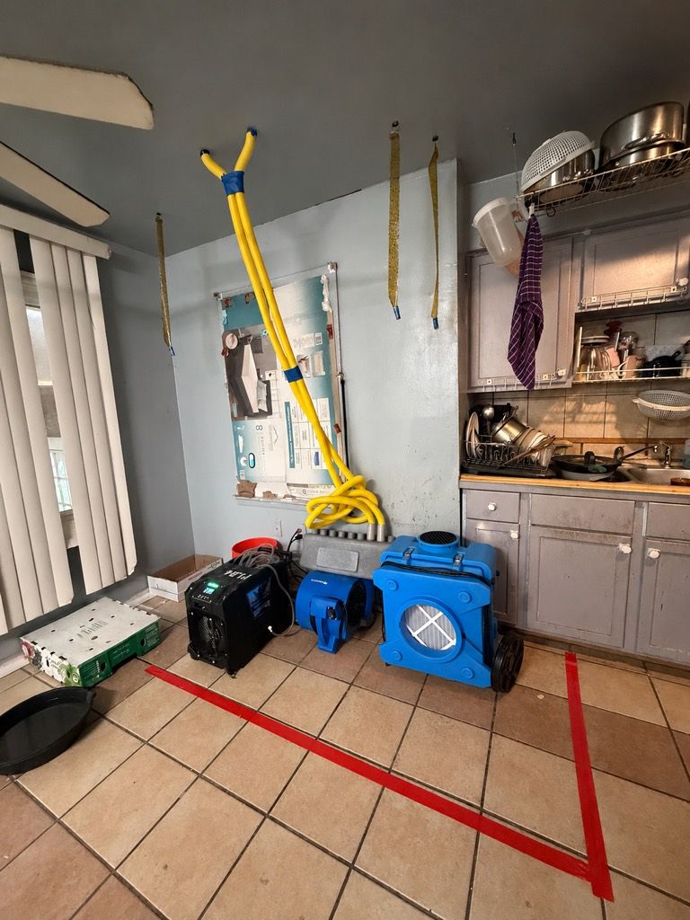 Commercial air movers drying a kitchen floor